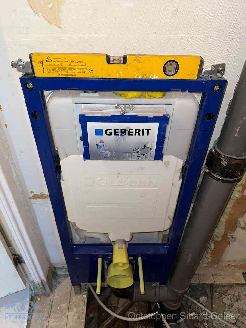 Een Geberit inbouwreservoir met frame voor een hangtoilet tegen de wand, met de afvoerbocht naar de vloer, kenmerkend voor een verstopt hangtoilet in Sittard-Geleen