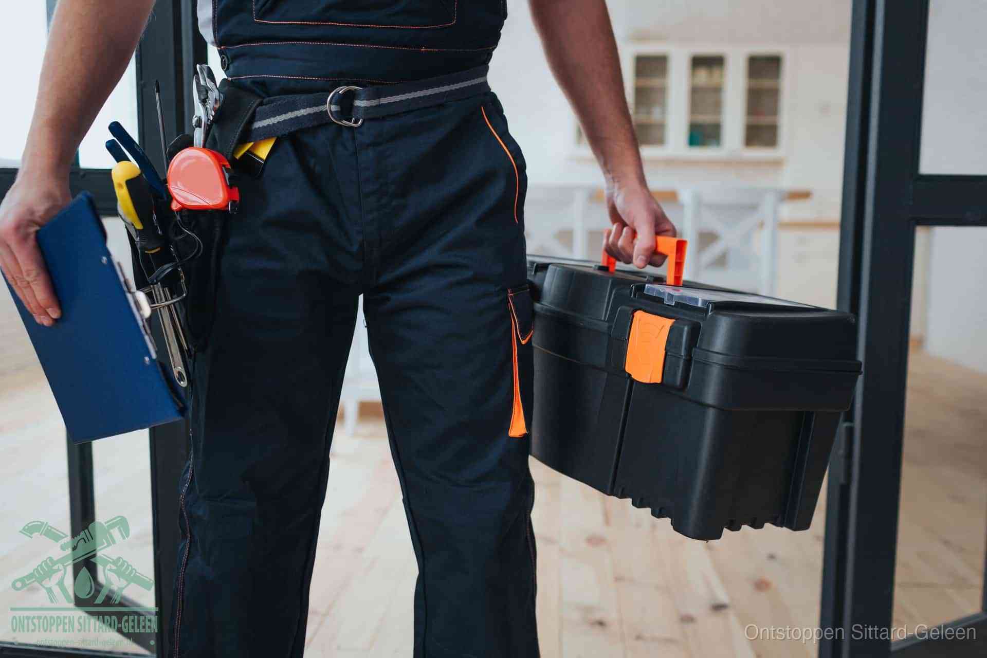 Een monteur met gereedschapsriem en klembord, klaar om een transparante prijs voor het afvoer ontstoppen in Sittard-Geleen te geven