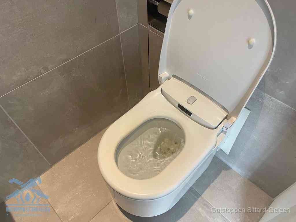 Een toiletpot vol troebel water met drijvend papier en restanten, de meest voorkomende oorzaak van een verstopte wc in Sittard-Geleen