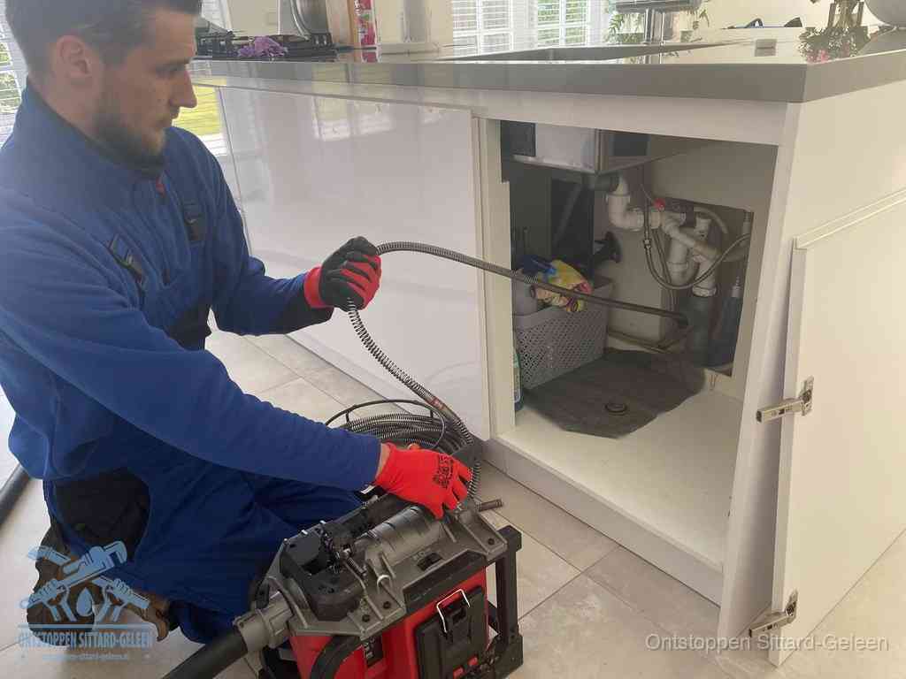 Een monteur reinigt de keukenafvoer grondig met een veermachine om terugkerende gootsteenverstoppingen te voorkomen in Sittard-Geleen