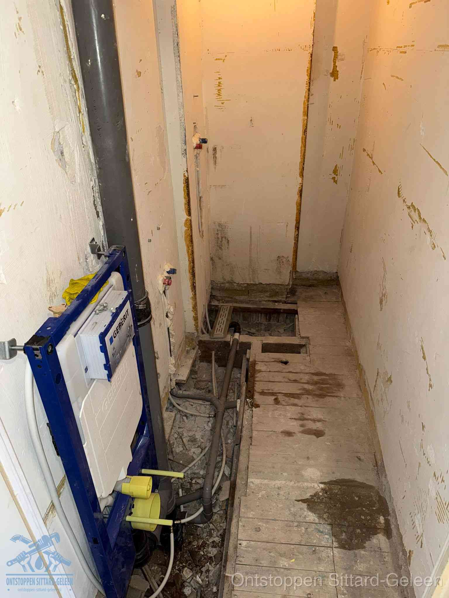 Een opgebroken toiletruimte tijdens renovatie met een Geberit inbouwreservoir en blootliggende oude afvoerleidingen, typisch voor oudere woningen in Sittard-Geleen